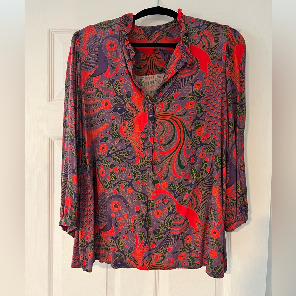 Large, flowy blouse with deep colors of red, purple, and green.
